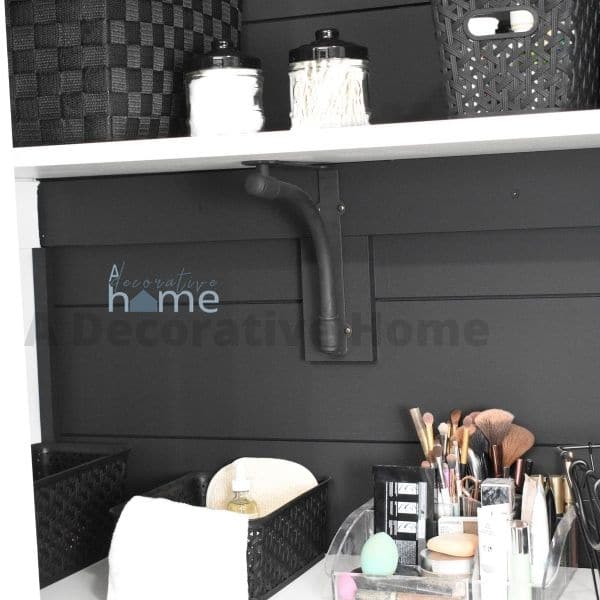 A bathroom closet that has been ship lapped and painted black.