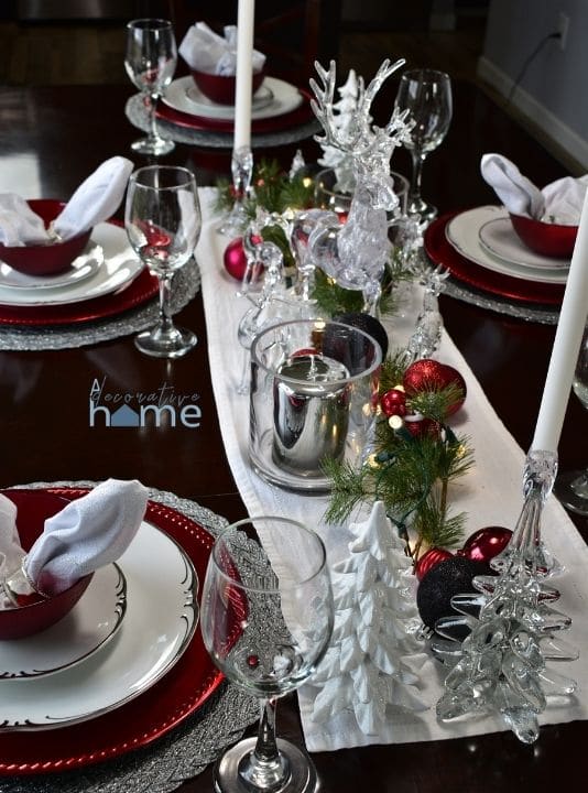 A table decorated for Christmas with red, silver, white, and black.