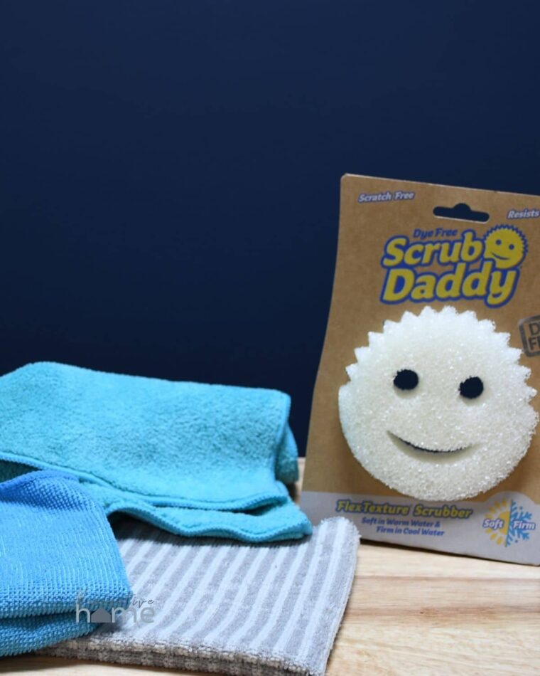 Essential cleaning tools like these microfiber cloths and a scrub daddy on a counter.